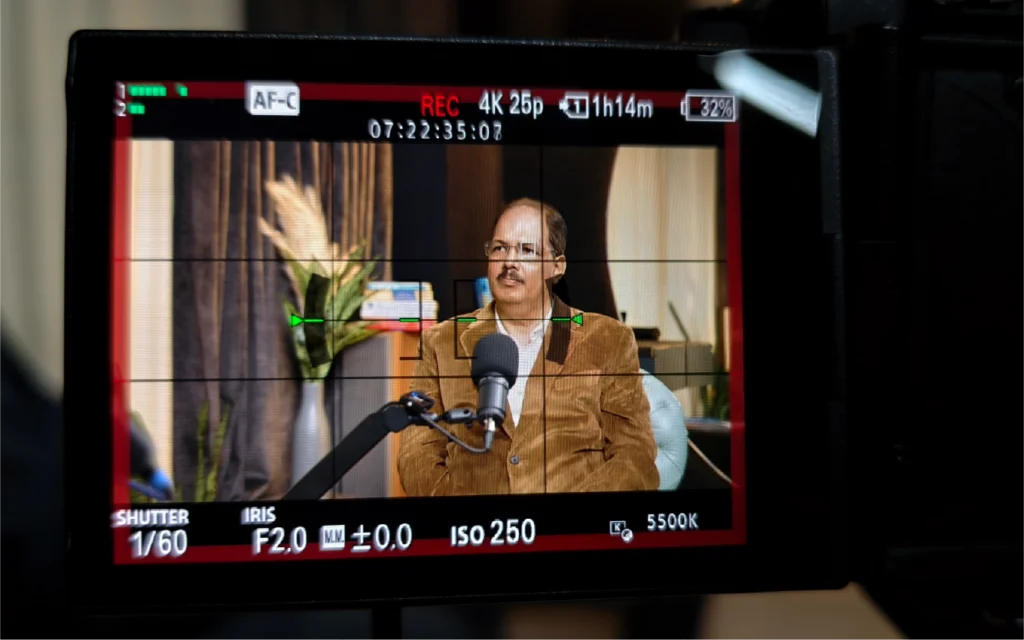 Podcast shoot in progress with camera screen framing the host during recording